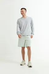 Sweater verde oscuro de tejido de punto, con escote en V y mangas largas.