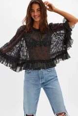 Blusa negra de encaje con cuello alto y mangas anchas con volados.