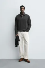 Polo de manga larga color gris oscuro, con diseño de textura estructurada, cuello solapa y cierre frontal de cremallera corta. Cuenta con puños y cintura de rib elástico.