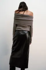Falda midi de tiro alto con diseño de tubo, confeccionada en material con efecto piel. Presenta una abertura frontal en el bajo y cierre con cremallera oculta en la costura.