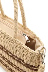 Bolso tipo shopper tejido en tono beige con detalles de rayas horizontales marrones, doble asa rígida de mano y correa larga ajustable y desmontable.