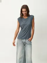 Remera blanca de corte clásico con cuello redondo y mangas cortas con detalle de hombreras.