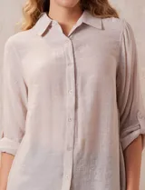 Camisa larga de rayón, con cuello clásico, cierre frontal con botones y mangas regulables con presilla. Presenta un diseño holgado con tajos laterales en el ruedo.