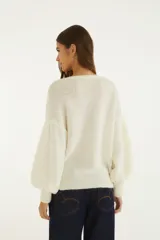 Sweater blanco de tejido de punto con escote en V, mangas largas y estampado ilustrado de inspiración tropical con flores y un leopardo en color negro.