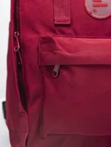 Mochila color verde militar con diseño clásico y minimalista. Cuenta con un compartimento principal con cierre de doble cremallera, un bolsillo frontal con cierre y dos asas superiores con broche. En el frente, tiene un parche circular con el texto "FORUM INDUSTRIES CO." en rojo.