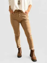 Pantalón de corte ajustado con efecto arrugado, confeccionado en tela liviana y elástica. Presenta cintura elastizada con lazo ajustable y bolsillos laterales.