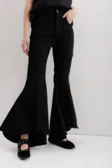 Jean elastizado azul oscuro con diseño de volados en la parte baja de la pierna, ruedo descosido con juego de largos (más largo atrás que adelante).