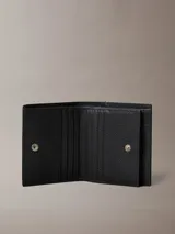 Billetera Calvin Klein trifold de cuero con textura granulada, compartimento interior grande y tarjetero.