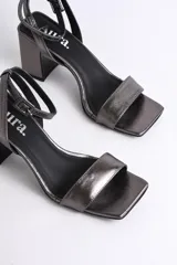 Sandalias plateadas de cuero con pulsera al tobillo y tacón cuadrado.