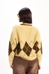 Sweater de punto con escote en V y calce relajado, con diseño de rombos en color bordó y celeste.