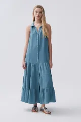 Vestido largo sin mangas color celeste, de bambula, con cuello camisero, abotonado al frente y falda con volados.