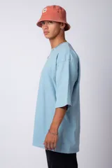 Remera de corte oversize, color blanco, con cuello redondo y mangas cortas amplias, confeccionada en algodón.