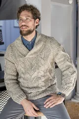 Sweater tejido a mano con ochos y cables, cuello cruzado a la base y terminaciones en punto elástico en puños y ruedo.