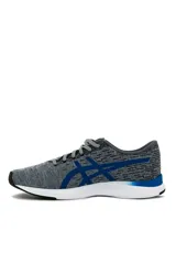 Championes deportivos Asics modelo Streetwise, color azul con diseño melange, suela blanca con detalles en naranja y el logo de la marca en tono rosado en el lateral.