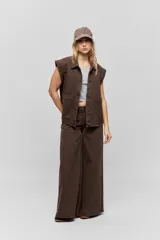 Musculosa de calce ajustado confeccionada en tejido acanalado, con escote redondo y detalle de puntilla en el escote y las sisas.
