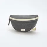 Riñonera gris de tela con cierre color crema y correa de algodón color crudo.