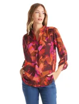 Blusa de gasa con estampado abstracto en tonos marrones, naranjas y fucsias. Presenta cuello mao con escote en V y mangas largas con sistema de ajuste mediante presilla y botón.