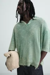 Polo de punto de algodón, color verde menta con efecto lavado que le da un aspecto desgastado y texturizado. Presenta un corte relajado (relaxed fit), cuello solapa con abertura frontal en V y mangas cortas.