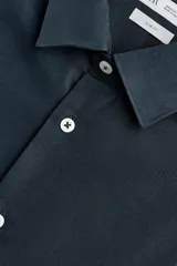 Camisa de hombre color beige claro, de corte slim fit, con cuello italiano, manga larga y cierre frontal de botonadura.