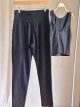 Pantalón slim negro de tiro alto confeccionado en lycra de algodón, con faja ancha de sostén y bolsillos delanteros y traseros.