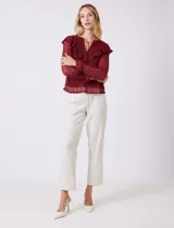 Blusa de encaje color beige, marca Cupio, con cuello a la base y escote en V con lazo de ajuste. Presenta una sobrecapa de encaje con aplique de puntilla y mangas largas de encaje floral translúcido, terminadas en puños elásticos con volado. Incluye forro interno a tono.