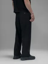 Pantalón cargo negro de corte oversize, confeccionado en microfibra elastizada. Presenta cintura elástica, bolsillos laterales y un bolsillo cargo con cierre de broche a presión. Incluye un sistema de elásticos con tancas en los tobillos para ajustar la apertura.