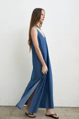 Vestido largo a rayas verdes y blancas, con escote redondo, sin mangas y aberturas laterales.