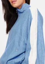 Chaqueta con cremallera color celeste con paneles blancos en las mangas.