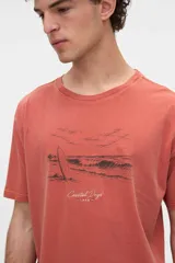 Remera de algodón lavado con textura suave, de manga corta y calce relaxed, color salmón con diseño estampado y bordado en el pecho.