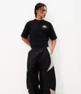 Pantalón barrel de poliéster color negro con recortes contrastantes en tono gris claro en los laterales, de corte amplio y urbano con cintura elástica.