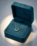 Collar de plata 925 con cadena fina y dije cuadrado con piedra de circonia color verde esmeralda rodeada de pequeñas piedras brillantes.