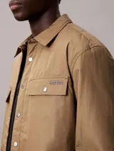 Sobrecamisa de algodón Calvin Klein con relleno ligero, diseño de corte regular, cierre frontal con botones a presión, bolsillos frontales con solapa y puños abotonados.