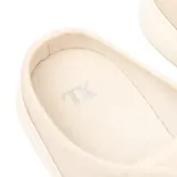 Zapatilla tipo mule color hueso, con diseño de frente cerrado con cordones y talón descubierto. Presenta puntera reforzada y suela de goma al tono.