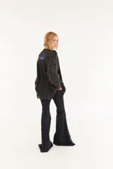 Sweater oversize unisex de tejido de punto con diseño de ochos y efecto lavado. Presenta cuello redondo, mangas largas y una franja central con letras en relieve.