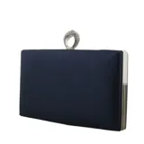 Cartera tipo clutch de fiesta en color azul marino, con acabado satinado y estructura rígida. Presenta un cierre superior con un original detalle de anillo decorado con pedrería brillante y marco metálico plateado.