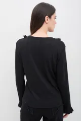 Remera de manga larga color blanco, confeccionada en tejido suave con textura acanalada. Presenta volados verticales decorativos en el frente y en los puños, con un calce cómodo y favorecedor.