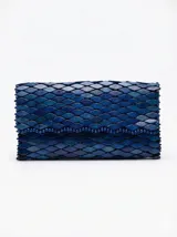 Cartera tipo clutch color azul, con diseño texturizado en relieve de escamas o cuentas de madera y cierre frontal.