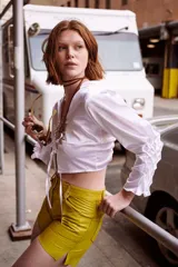 Camisa verde militar de seda con escote en V, mangas largas abullonadas y cierre frontal con lazo.