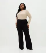 Pantalón de corte flare confeccionado en tejido punto roma, con cintura alta, nervadura delantera y acabado estructurado.