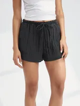 Short negro de tela arrugada con cintura elástica y cordón ajustable.