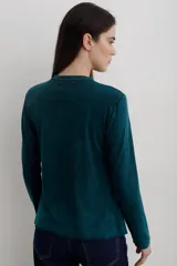 Remera de manga larga con efecto lavado, cuello redondo y estampa frontal con diseño de estrella y texto.