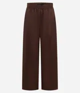 Pantalón de corte barrel con piernas anchas y cintura elástica, confeccionado en tejido técnico de poliéster y poliamida.