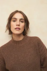 Polera de tejido de punto acanalado color marrón, con cuello alto y mangas largas con puños doblados.