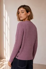 Cardigan de punto con diseño de ochos, color rojo, cuello redondo y cierre frontal con botones. Cuenta con manga larga y detalle bordado en el pecho.
