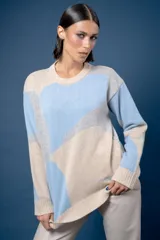 Buzo de punto con diseño abstracto que simula un paisaje, cuello redondo y mangas largas. Confeccionado en lana, presenta una combinación de colores en tonos beige, celeste y gris.