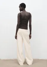 Pantalón de tiro alto estilo wide leg, color blanco, con trabillas para cinturón, bolsillos laterales y cierre oculto con botón, gancho y cremallera. Confeccionado en tejido de algodón.