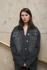 Campera de jean gris oscuro con bolsillos frontales y cierre con botones.