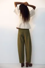 Pantalón de sarga de algodón verde militar, de tiro alto con piernas estilo barrel y costuras frontales destacadas. Cuenta con cierre de cremallera y botón oculto, bolsillos discretos en las costuras laterales y bolsillos traseros insertados.