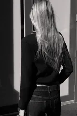 Jersey de punto color azul marino, de manga larga, con cuello polo y cierre frontal de botones. Presenta vivos blancos con borde ondulado en el cuello, puños y ruedo inferior.