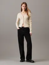 Cárdigan color crema de punto de algodón suave con textura de canalé, corte slim, cuello en V, manga larga, cierre de botones e insignia tonal de Calvin Klein en el bajo.